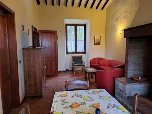 Podere Il Caggio Rooms في سان جيمنيانو: غرفة معيشة مع طاولة ومدفأة