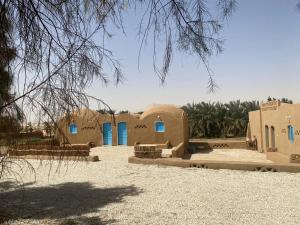 una casa en el desierto con puertas azules en Beir El Gabal Hotel (with Hot Springs) en Al Qaşr