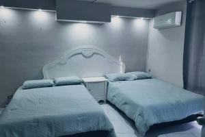 two beds sitting next to each other in a bedroom at Casa alberca cerca de todo. zona pastora. cochera in Monterrey +12 photos