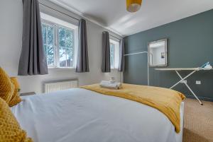 a bedroom with a large bed and two windows at NEC Exhibitor Home, Stay near Birmingham Airport in Birmingham