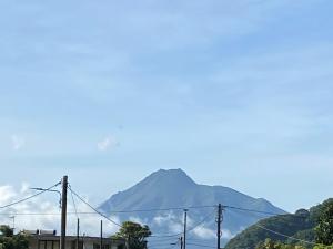 a mountain in the distance with power lines at Villa Montjoly in Le Morne-Vert