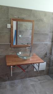 a mirror on a wooden table in a bathroom at Villa Montjoly in Le Morne-Vert
