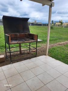 uma churrasqueira sentada sob um guarda-chuva num campo em Moras Morada em Almafuerte