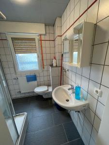 ein Bad mit einem Waschbecken und einem WC in der Unterkunft estrella24 LIVING ROOMS Amsterdam in Castrop-Rauxel