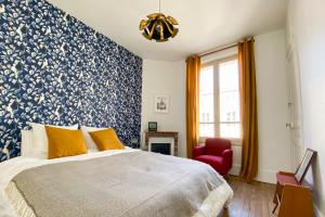 a bedroom with a blue and white patterned wall at Appartement historique cœur de ville, chic et cosy in Rambouillet
