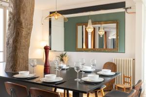 comedor con mesa con sillas y espejo en Appartement historique cœur de ville, chic et cosy, en Rambouillet