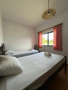 una camera con due letti e una finestra con tende rosse di Villa Facho ad Alvor Altre 22 foto