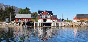 a house on a dock in the water at Cabin Borgvåg Small in Straum