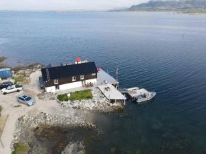 an aerial view of a house with a boat in the water at Cabin Borgvåg Small in Straum