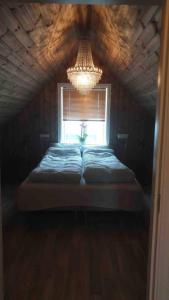 a bed in a room with a window and a chandelier at Cabin in Borgvåg Lofoten - Large in Straum