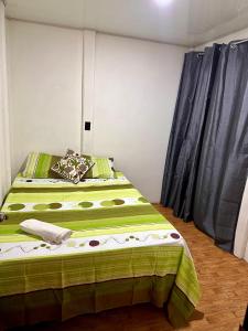 um quarto com duas camas com lençóis verdes em Casa caribes em Puerto Limón