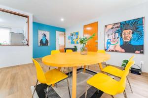a dining room with a wooden table and yellow chairs at NEW Exciting Roma Condo Parque Mexico 550m Walk in Mexico City