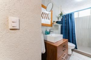 a bathroom with a sink and a toilet and a mirror at NEW Exciting Roma Condo Parque Mexico 550m Walk in Mexico City