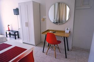 a room with a table with a mirror and a red chair at Dimitris City Break Apts in Chania Town