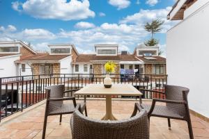 a patio with a table and chairs on a balcony at Serene, Escape Haven in Kileleshwa in Nairobi