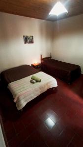 a bedroom with two beds and a light on the wall at Postales del Tiempo in Tilcara