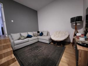 ein Wohnzimmer mit einem weißen Sofa und einem Stuhl in der Unterkunft Cozy room in big Apartmet in Mexiko-Stadt