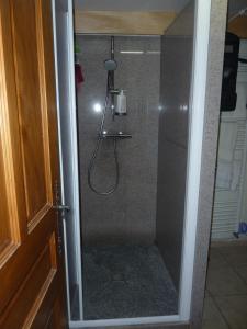 La salle de bains est pourvue d'une douche avec une porte en verre. dans l'établissement Chalets Pyrene Mont-Blanc, à Chamonix-Mont-Blanc