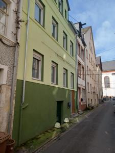 un edificio verde y amarillo al lado de una calle en Luxus Ferienhaus Janina, en Zell an der Mosel