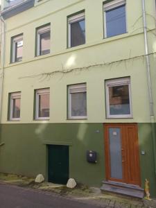 un edificio verde con una puerta de madera en una calle en Luxus Ferienhaus Janina, en Zell an der Mosel