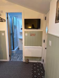 a hallway with a flat screen tv on a wall at The Little Garden Hideaway with Stunning Sea Views and Garden in Holyhead