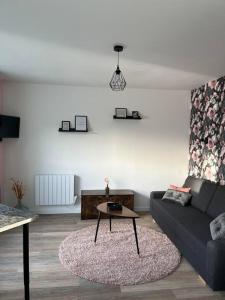 a living room with a couch and a table at Le petit Tournebride in Paimpol