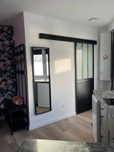 a bathroom with a mirror on the wall and a chair at Le petit Tournebride in Paimpol +3 photos