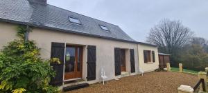 Casa blanca con ventanas negras y patio en La fermette 72 - Les Contensières, en Saint-Vincent-du-Lorouër