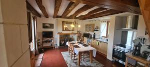 Una cocina con una mesa y sillas en una habitación. en La fermette 72 - Les Contensières, en Saint-Vincent-du-Lorouër