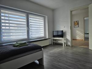 - une chambre avec un lit et 2 grandes fenêtres dans l'établissement An der Dorfeiche, à Hamm
