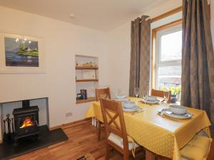 a dining room with a table and a fireplace at Tigh a Phailean in Letterfearn