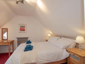 a bedroom with a white bed with blue towels on it at Tigh a Phailean in Letterfearn