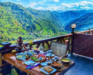 ArdeşenにあるRizeHayatburdabungalovの山の景色を望むバルコニーの上にテーブルと食べ物