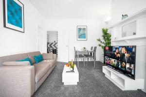 a living room with a couch and a flat screen tv at Harborne 2 Bedroom House - Parking - Smart TV - Wifi - 62W in Birmingham