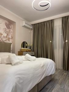een slaapkamer met een groot wit bed en een raam bij Comfort Apartment Tirane in Tirana