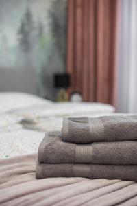 a pile of towels sitting on top of a bed at WARSZAWSKI SEN. Apartament na 5 in Warsaw