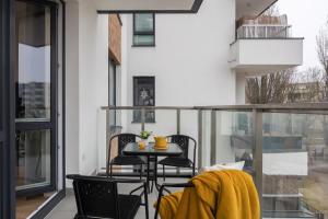 a balcony with a table and chairs on it at WARSZAWSKI SEN. Apartament na 5 in Warsaw