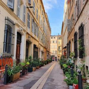 an empty street in a city with buildings and plants at Hotel Du Centre in Marseille