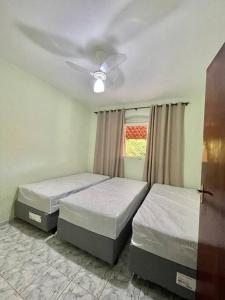 - une chambre avec 2 lits et un ventilateur de plafond dans l'établissement Casa de campo com piscina, à Socorro