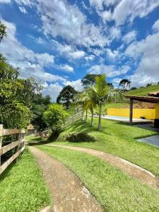 un camino de tierra con palmeras junto a una valla en Casa de campo com piscina, en Socorro