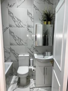 La salle de bains blanche est pourvue de toilettes et d'un lavabo. dans l'établissement Stylish One Bedroom Apartment in the heart of Angel, à Londres