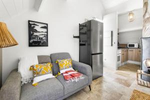 een woonkamer met een bank en een koelkast bij Evasion romantique - Studio les pieds dans l'eau in Saint Martin