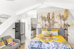 een slaapkamer met een bed met een gele sprei bij Evasion romantique - Studio les pieds dans l'eau in Saint Martin