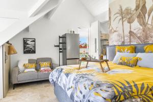 um quarto com uma cama king-size e um sofá em Evasion romantique - Studio les pieds dans l'eau em São Martinho