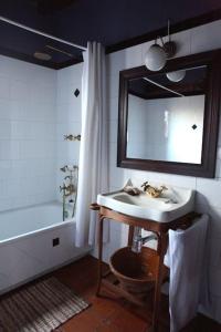 a bathroom with a sink and a mirror and a tub at La Casa de las Pajaritas in Pasarón