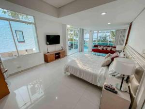 Habitación grande de color blanco con cama y TV. en Casa VIP en Cartagena cerca a la playa, en Cartagena de Indias