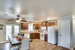 a kitchen with a table and a white refrigerator at Fire Pit and Covered Patio Bullhead City Escape! in Bullhead City