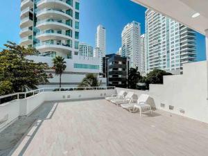 un grupo de sillas sentadas en un patio con edificios en Casa VIP en Cartagena cerca a la playa, en Cartagena de Indias