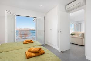 a bedroom with two beds and a large window at S'Embat sea views in Alcudia