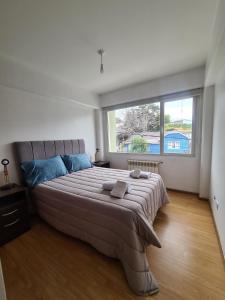 a bedroom with a large bed with a large window at Belgrano Ushuaia in Ushuaia